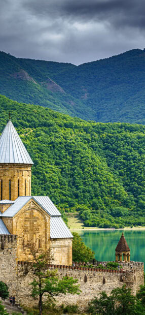 Ancient Georgia castle surrounded by lush green mountains and lake view