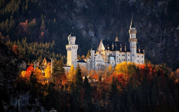 Neuschwanstein castle surrounded by colorful autumn forest in Germany