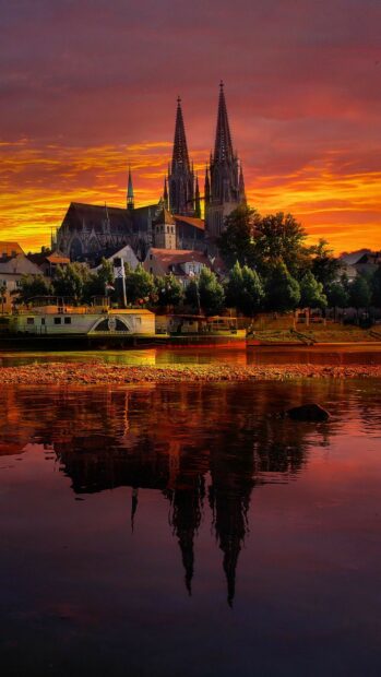 Stunning sunset over Germany historic cathedral and riverside reflection
