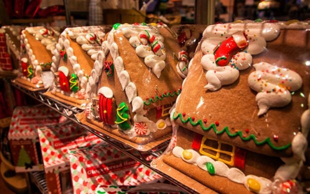 Close up of decorated gingerbread house with candy and icing on display shelf