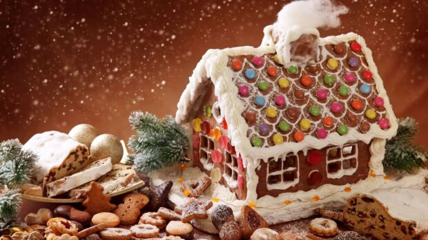 A festive gingerbread house decorated with colorful candies and surrounded by holiday cookies and pine branches