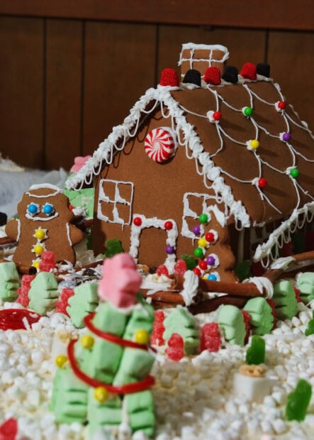 Detailed gingerbread house with candy decorations and a gingerbread man nearby