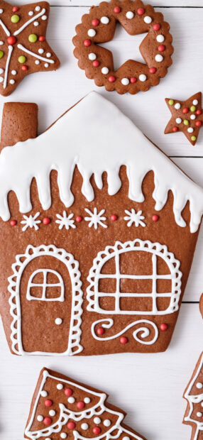Gingerbread house decorated with icing and candy on a wooden surface