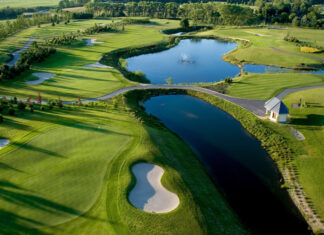 A beautifully maintained golf course with green fairways and water hazards on a sunny day