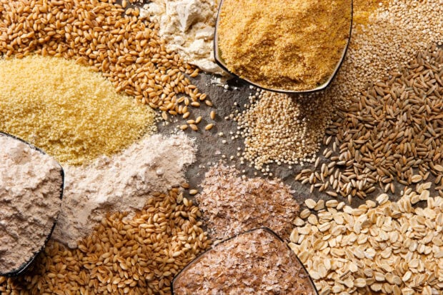 Various grains and cereals arranged on a dark surface showcasing different textures and colors of grains