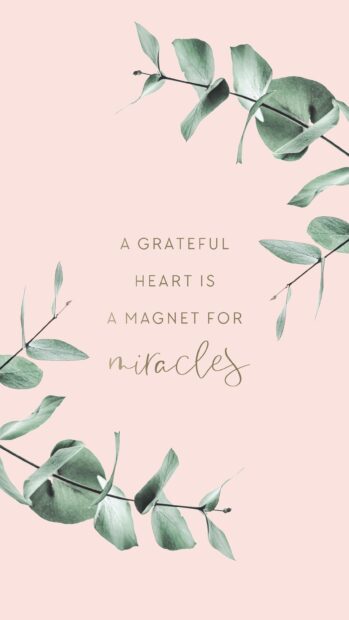 A grateful heart is a magnet for miracles quote with green leaves on a soft pink background