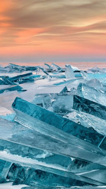 Clear frozen blocks of Greenland ice under a soft pastel sky