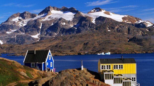 Traditional Greenland houses near a lake with mountains in Greenland