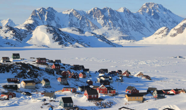 Colorful houses in Greenland village surrounded by snow and Greenland mountains
