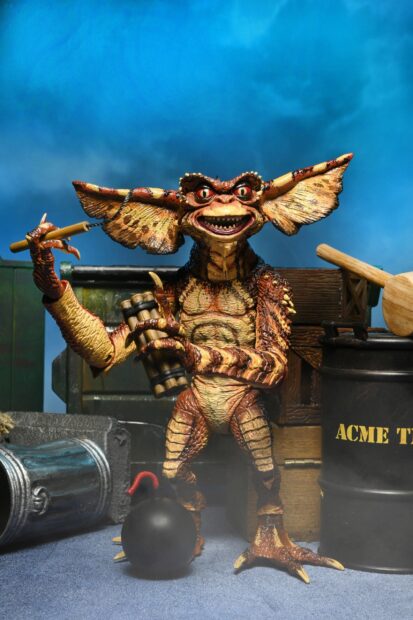 A gremlin character holding dynamite sticks in a detailed scene with an explosive device and barrels in the background