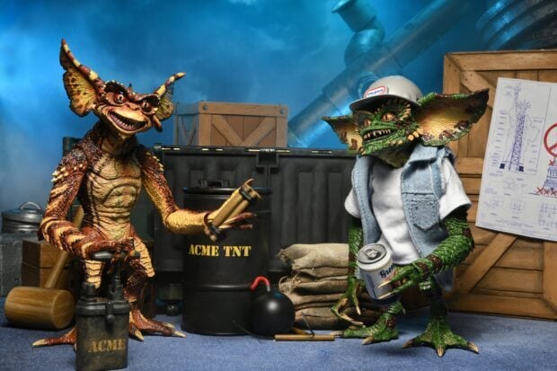 Two gremlin characters preparing explosives in a workshop setting with crates and tools around them