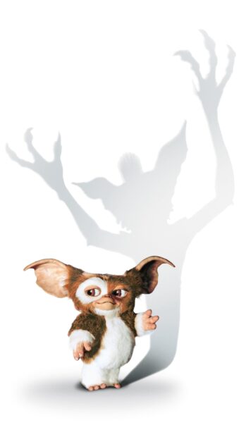 A cute gremlin character standing with a large shadow showing raised hands in the background