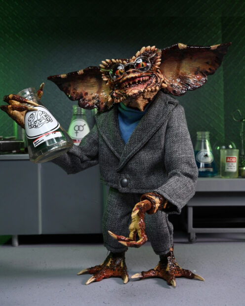 Gremlin wearing a gray suit and glasses holding a chemistry flask in a lab setting