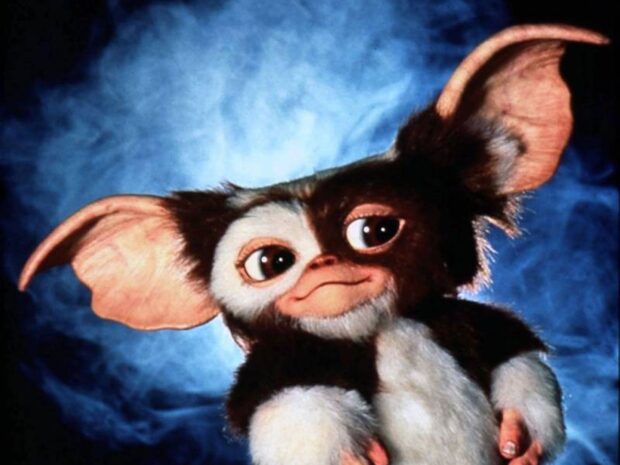 A cute gremlin with large ears and big eyes against a blue smoky background