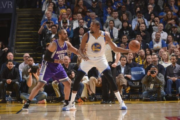 Basketball player wearing warriors jersey holding ball during game