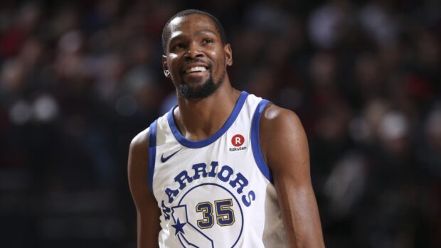 Smiling basketball player wearing number 35 Warriors jersey on the court
