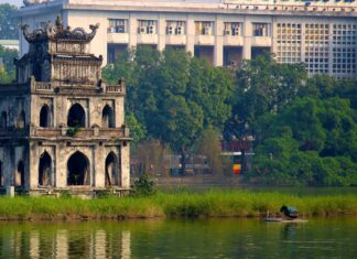 The ancient tower on the small island with lush greenery in Hanoi lake