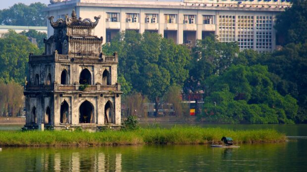 The ancient tower on the small island with lush greenery in Hanoi lake