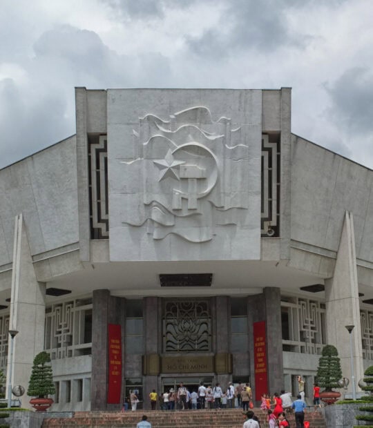 The Ho Chi Minh Museum facade featuring communist star and people visiting