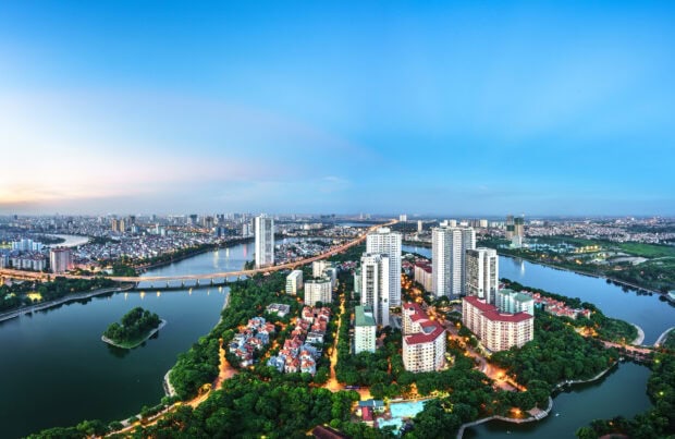 A panoramic view of Hanoi cityscape with modern buildings and rivers surrounding the urban area