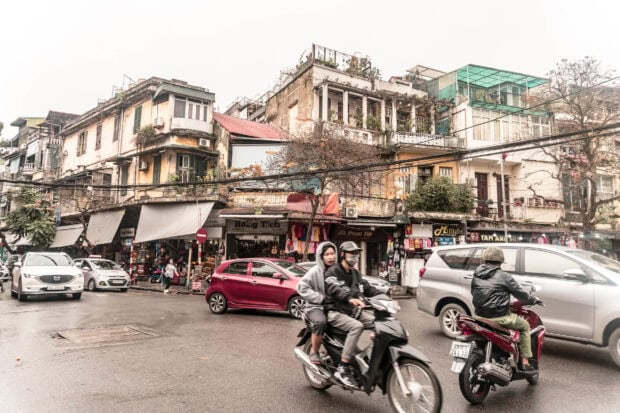 Busy street scene with old architecture and motorbikes in Hanoi city center