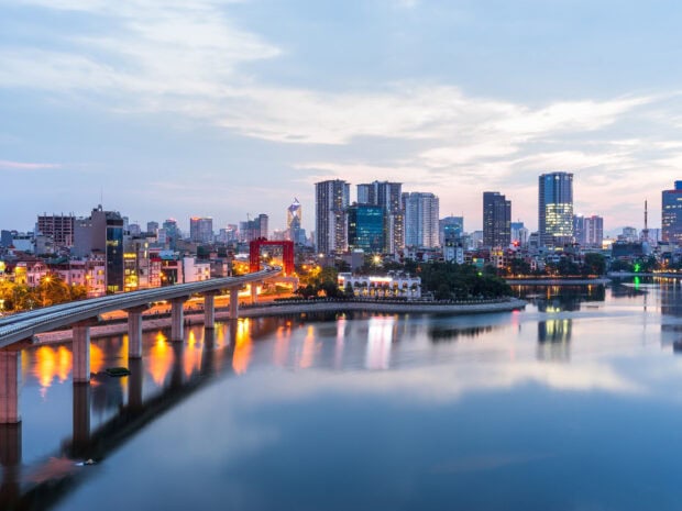 Hanoi city skyline with the Red Bridge and river at dusk in a peaceful evening view