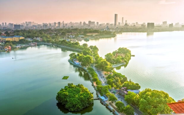 A scenic view of Hanoi city with green islands and cityscape under morning light