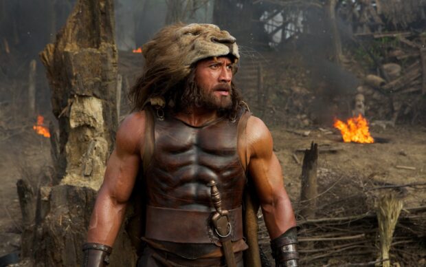 Hercules Wallpapers 2K Desktop A muscular man wearing a lion head helmet and leather armor in a forest setting