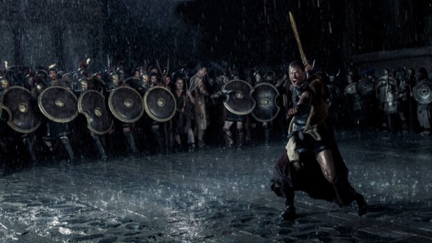 Hercules leading warriors in armor amidst heavy rain during battle scene
