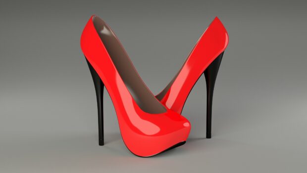 A pair of red high heels with black stiletto heels on a gray background