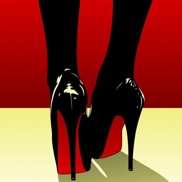 Black high heels with red soles on a light floor with red heels displayed