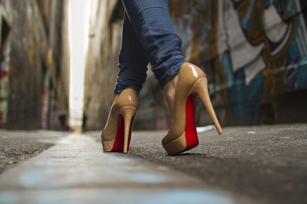 Close up of high heels on a person walking down an urban alleyway