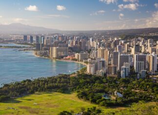 A panoramic view of Honolulu cityscape with lush green parks and blue ocean in Honolulu