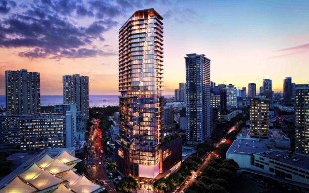 Modern high rise building in Honolulu cityscape at sunset with ocean in the background