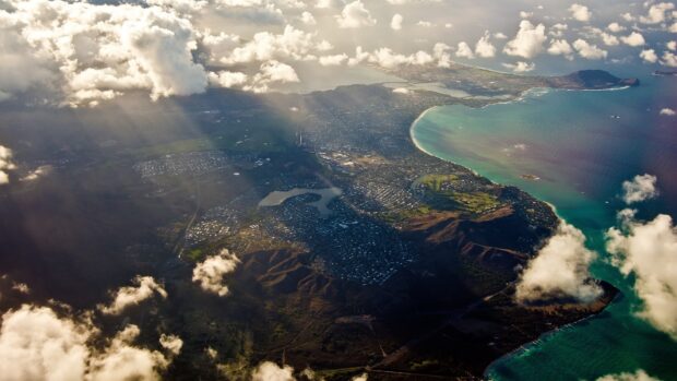 Aerial view of Honolulu coastline and city with clouds and mountains in Hawaii
