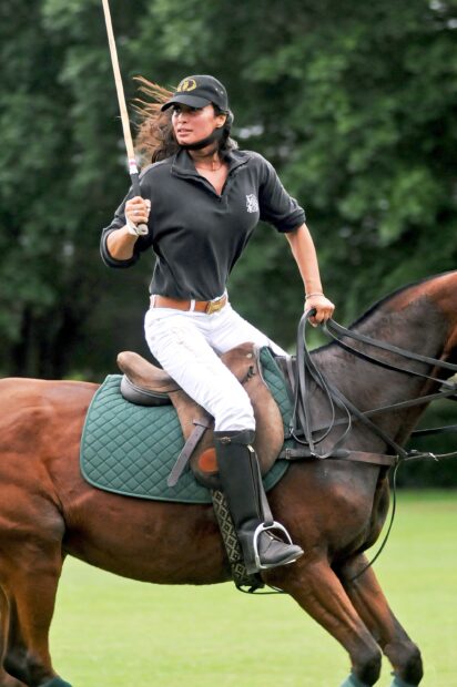 Female horse polo player riding a horse in action during a polo match