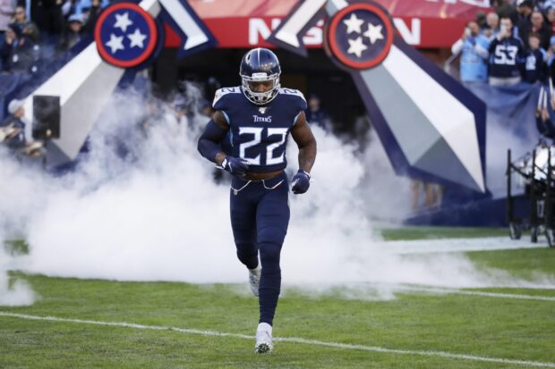 Football player in Titans uniform running onto the field with smoke around in a Houston Texans game