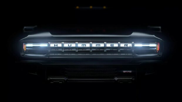 Front view of Hummer grille with illuminated headlights in dark environment