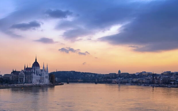 Beautiful sunset over the historic parliament building in Hungary with river and cityscape