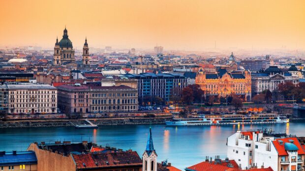 Cityscape of Hungary with historical buildings along the river at sunset