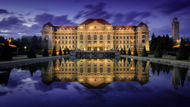 Historic building in Hungary reflected in calm water at twilight