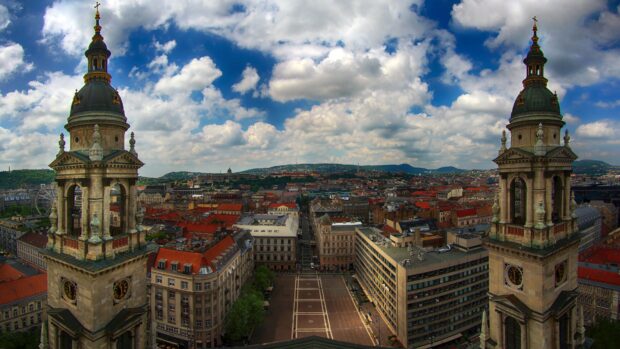 Historic towers of Hungary cityscape with cloudy sky and urban buildings