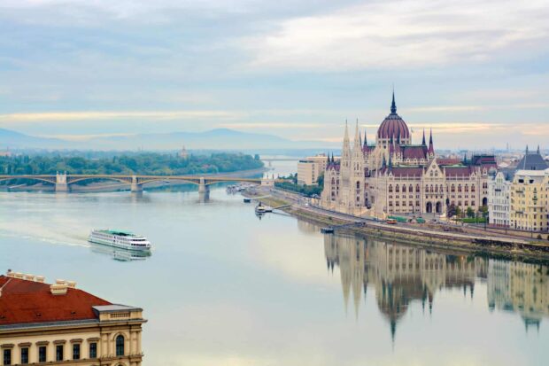 The Danube River flowing past the Hungarian Parliament in Budapest with a boat on the water
