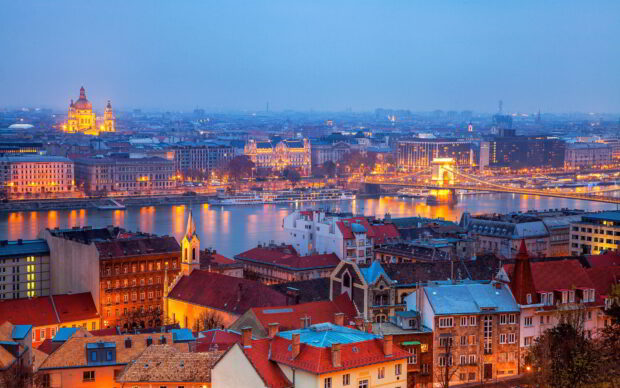 Evening cityscape of Budapest with Danube River and illuminated buildings including historic architecture