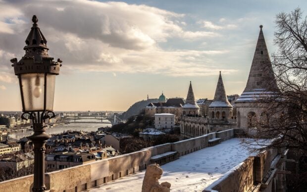 Historic architecture and river view in Hungary cityscape with snow covered stone walkway