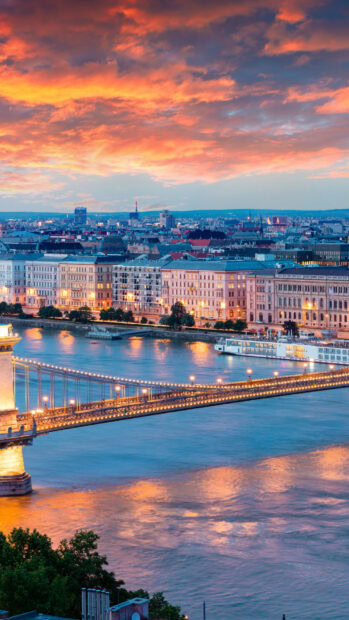 Beautiful sunset over Budapest cityscape in Hungary with river and illuminated bridge