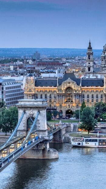 Historic Budapest skyline with chain bridge over river at dusk