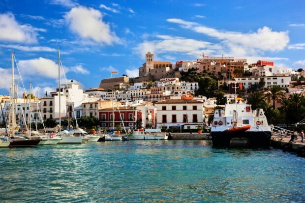 Beautiful Ibiza town with boats and vibrant buildings under a clear blue sky