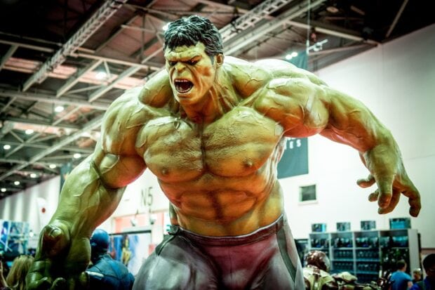 Incredible Hulk figure showing angry expression with muscular body in a convention hall