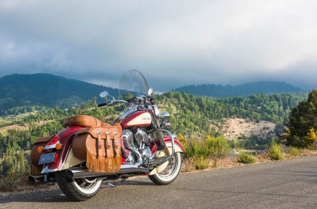 Classic Indian motorcycle with leather saddlebags parked on mountain road